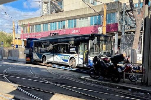 L’immagine mostra un autobus urbano destinato al servizio pubblico, rappresentativo della transizione verso mezzi a basse emissioni. Il veicolo è ripreso in un ambiente stradale urbano e presenta una carrozzeria moderna, ampie superfici vetrate e porte per la salita dei passeggeri. La fotografia richiama il tema del rinnovo tecnologico della flotta autobus romana.