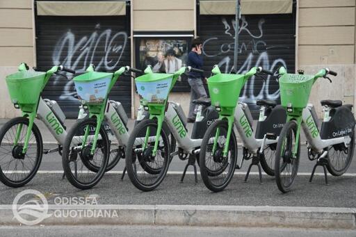 Immagine con monopattini elettrici in sharing parcheggiati lungo una strada urbana di Roma. Sono riconoscibili diversi mezzi appartenenti ai principali operatori presenti in città, disposti vicino al marciapiede. Sullo sfondo si vedono edifici, alberi e traffico cittadino. La fotografia rappresenta il servizio di micromobilità condivisa coinvolto nella decisione dell'Autorità garante relativa ai Pass gratuiti destinati agli abbonati Metrebus.
